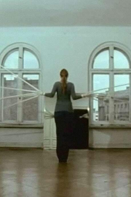 A series of performance pieces filmed specifically for the camera, each exploring interventions on the human body. The works employ materials such as feathers, hair and garment‑like sculptures worn by the performer, and are staged against a neutral backdrop or an empty outdoor setting, highlighting the interaction of body, object and space.